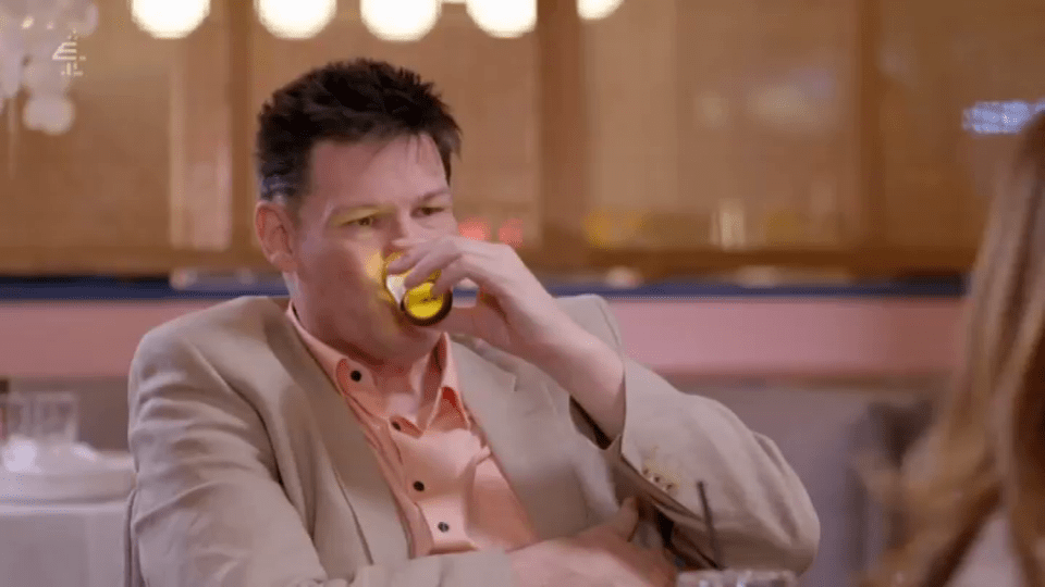 Man drinking from a small glass.
