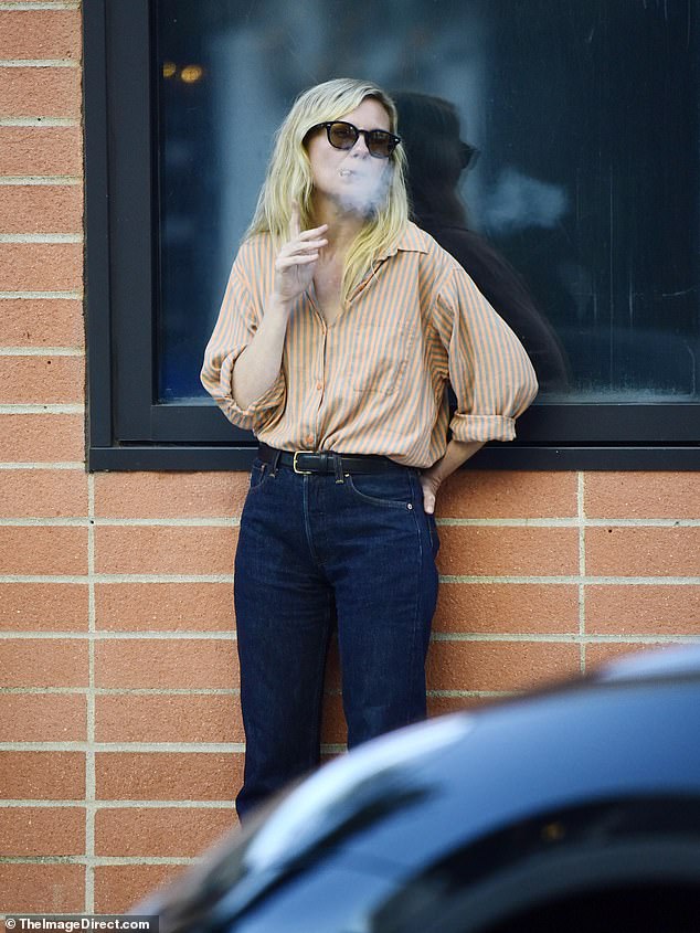 The Interview with the Vampire star cut a casual figure as she puffed on a cigarette while out with a friend