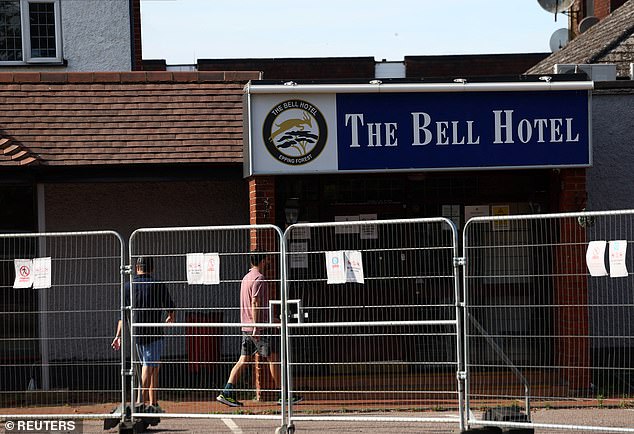 Men walk in The Bell Hotel, following Tuesday's High Court ruling in London that granted a temporary injunction to stop asylum seekers from being housed at the site