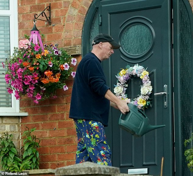 The former Tory councillor was seen watering flowers in preparation for his wife's release from prison today