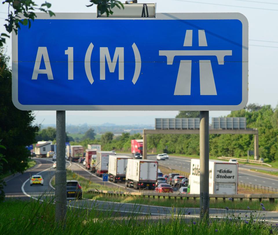 A1(M) motorway sign with a traffic jam in the background.