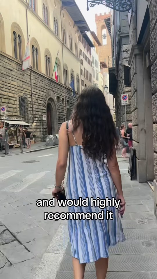 Woman walking down a Roman street.