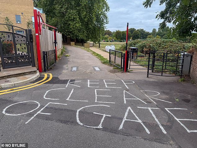 Outside of the entrance to the leafy park, 'keep clear of the gate' is written in chalk on the ground, though it is unknown whether this was written prior to the travellers descending on the leafy park