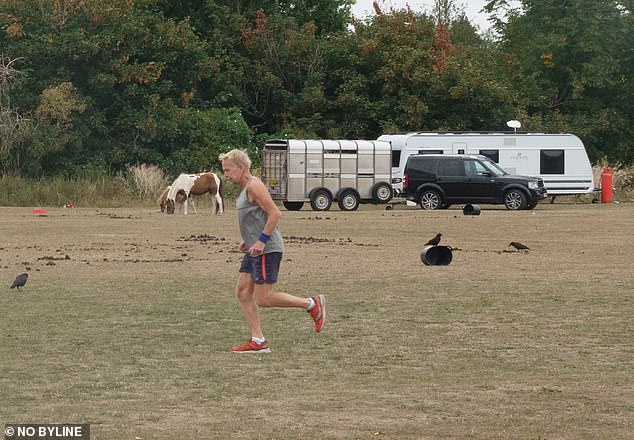 Pictured: a man is seen running alongside the scores of caravans and cars