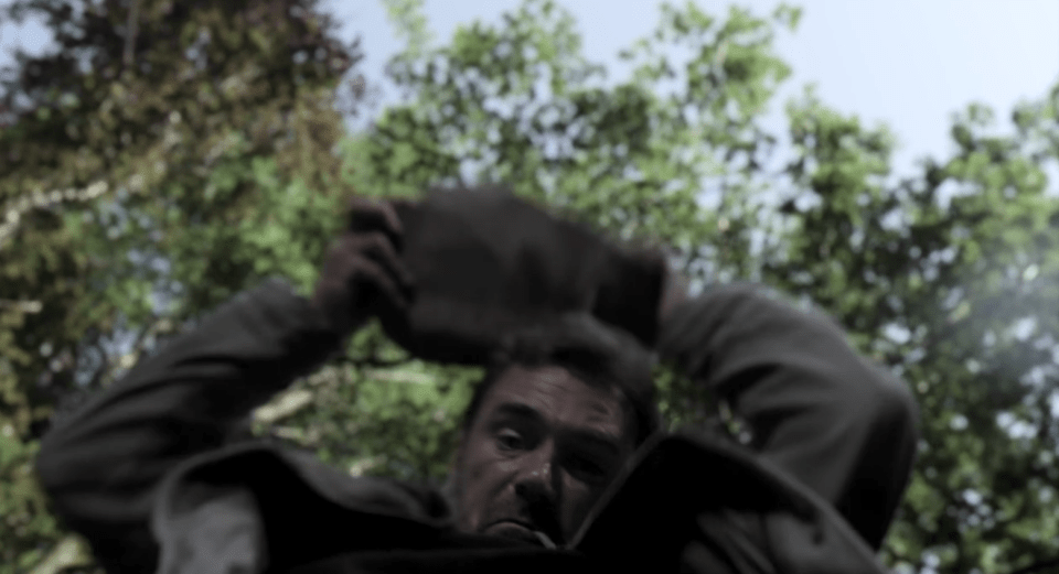 A man is struck on the head with a rock.