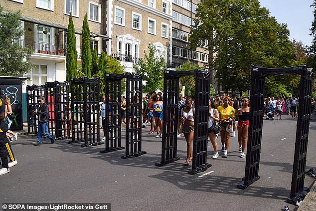 People pass through metal detectors at Notting Hill Carnival in West London in August 2024