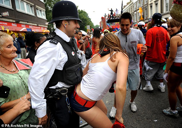 A dancer gets close to a police officer at the Notting Hill Carnival in London in August 2019