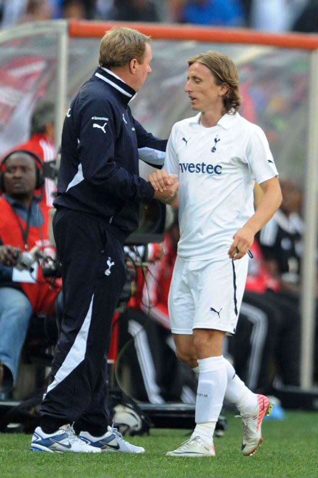 Harry Redknapp and Luka Modric shaking hands at a soccer game.