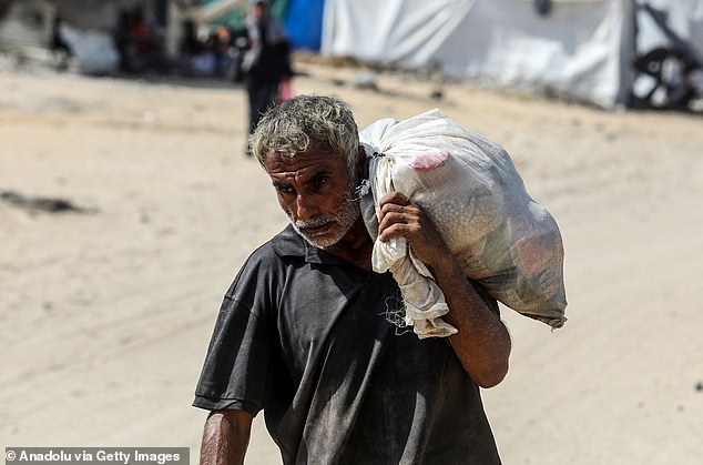 Pictured: Palestinians displaced by Israeli attacks flock to a US aid distribution center to receive food assistance in Rafah, Gaza, on August 14