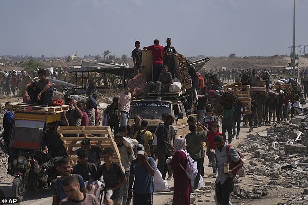 Pictured: Palestinians carry humanitarian aid packages near a Gaza Humanitarian Foundation distribution center