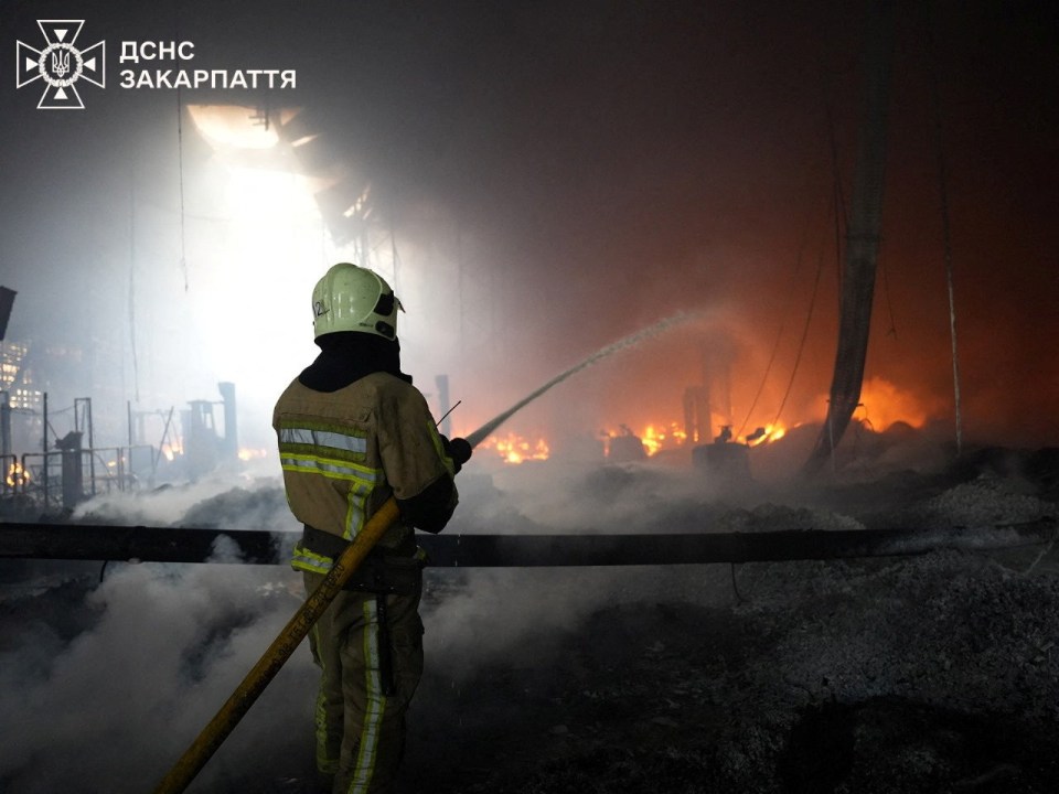 Firefighter battling a fire at a damaged factory.