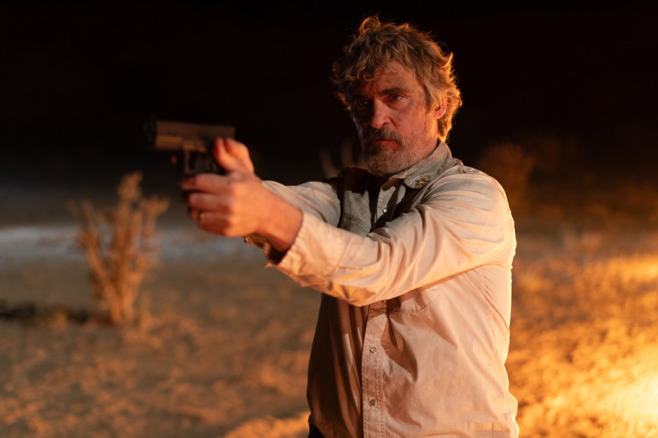 Joaquin Phoenix as Joe Cross aiming a gun in a film still.