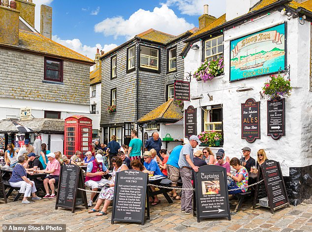Holidaymakers try the culinary offerings of the Sloop Inn in popular seaside destination, St Ives, Cornwall