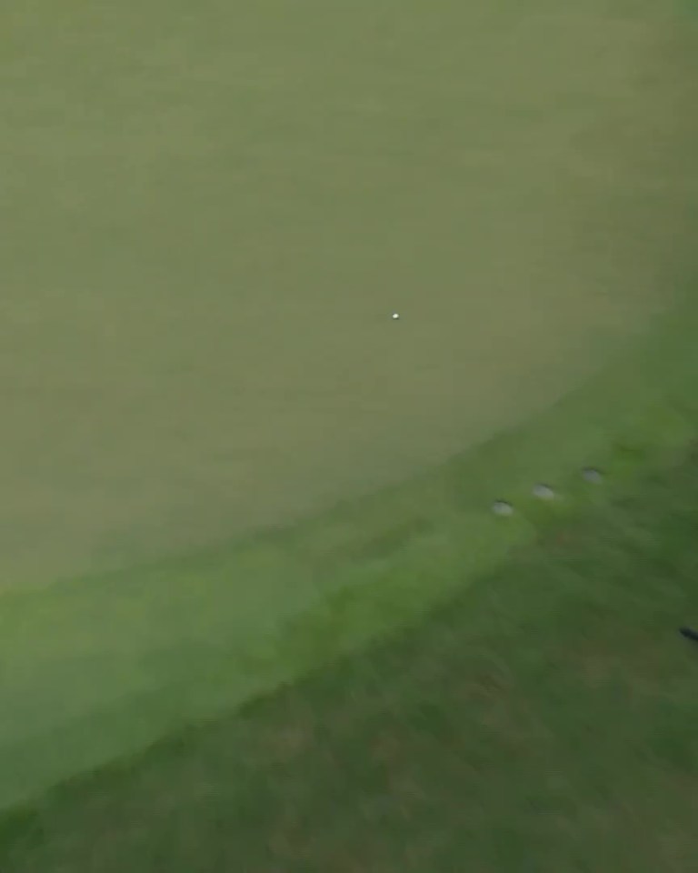 Rory McIlroy making a trick shot on a golf course.