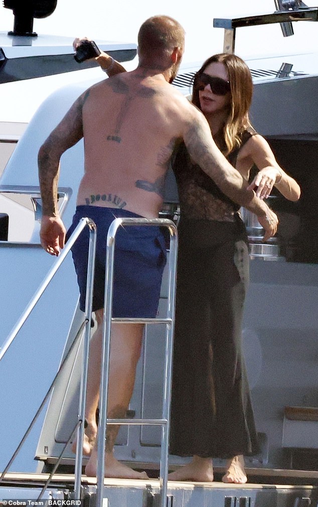 The lovebirds embraced on deck with David unable to keep his hands off his wife who was busy taking photos of their sons in the sea