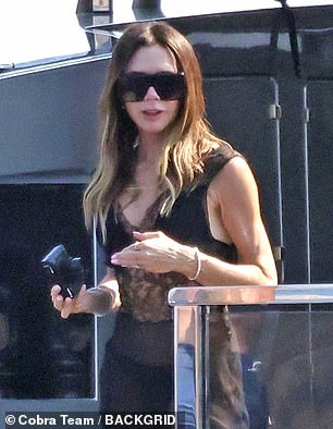 Meanwhile Victoria, who shielded her eyes behind shades, looked effortlessly chic in a black satin dress with lace panelling which she appeared to layer over a bikini