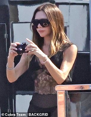 Meanwhile Victoria, who shielded her eyes behind shades, looked effortlessly chic in a black satin dress with lace panelling which she appeared to layer over a bikini