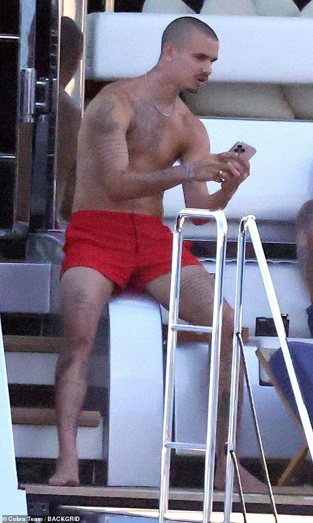 Just like his dad Romeo showed off his gym toned and tattooed physique