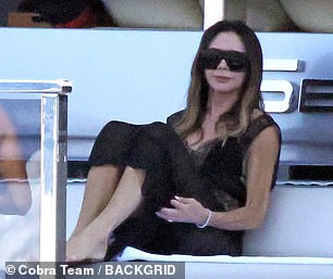 Victoria looked effortlessly chic as she watched the family frolic in the sea