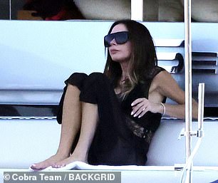 Victoria looked effortlessly chic as she watched the family frolic in the sea