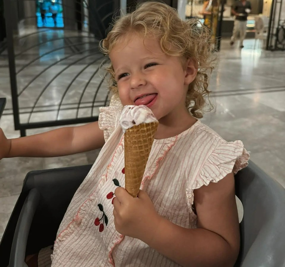 Toddler eating ice cream cone.