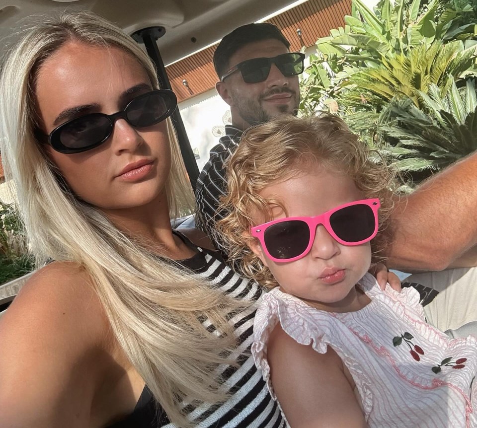 Molly Mae, her partner, and their daughter in a golf cart.