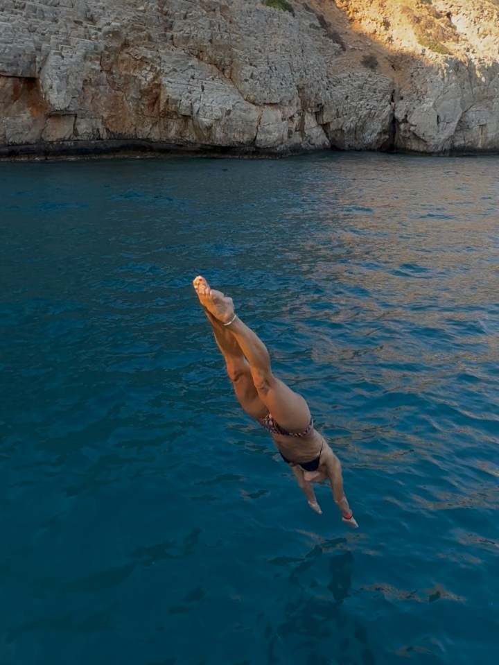 Woman in bikini diving into ocean.