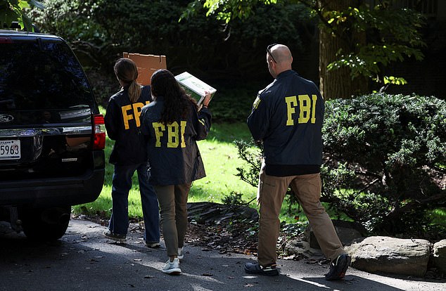 FBI members carry boxes to the home of the former White House national security adviser John Bolton as it is searched by FBI, in Bethesda, Maryland, U.S., August 22, 2025. REUTERS/Tasos Katopodis