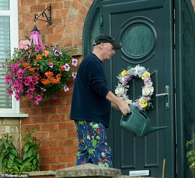 The Tory councillor was seen watering flowers in preparation for his wife's release from prison yesterday