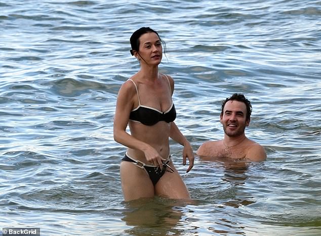 For her beach day, she was decked out in a skimpy monochrome two-piece that included a bandeau-style top, offering up a generous helping of cleavage