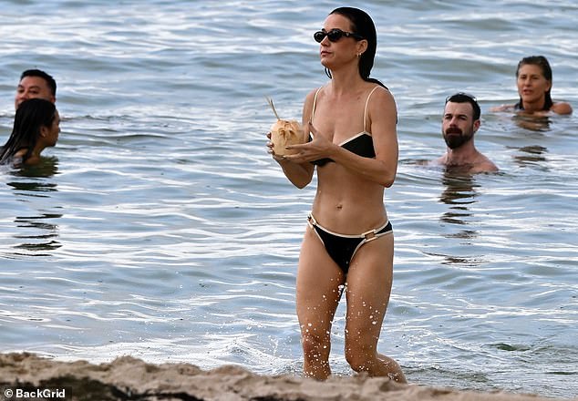 Opting for a minimalistic look where makeup was concerned, she swept her drenched hair back and accessorized with a sleek set of shades