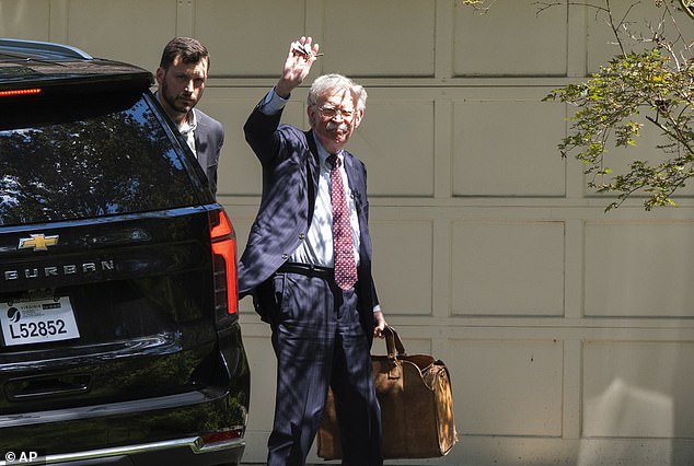 Bolton waved to cameras while entering his home but did not take questions from reporters