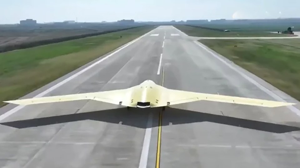 Stealth flying wing aircraft on a runway.