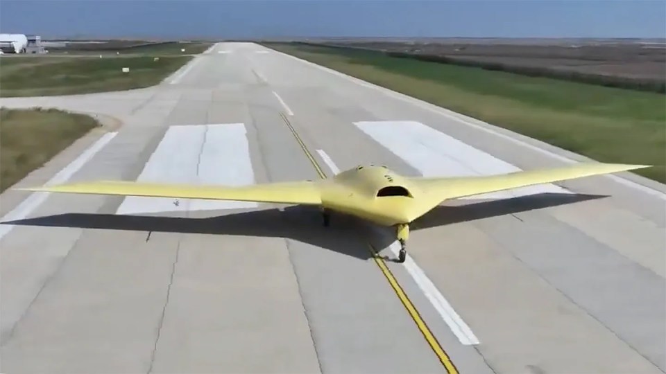 Yellow flying wing aircraft on a runway.