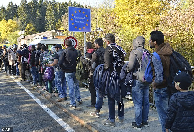 German federal police officers guide a group of migrants on their way after crossing the border between Austria and Germany in October 2018