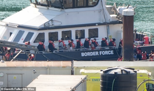 A group of people thought to be migrants are brought in to the Border Force compound in Dover, Kent, from a Border Force vessel on August 15