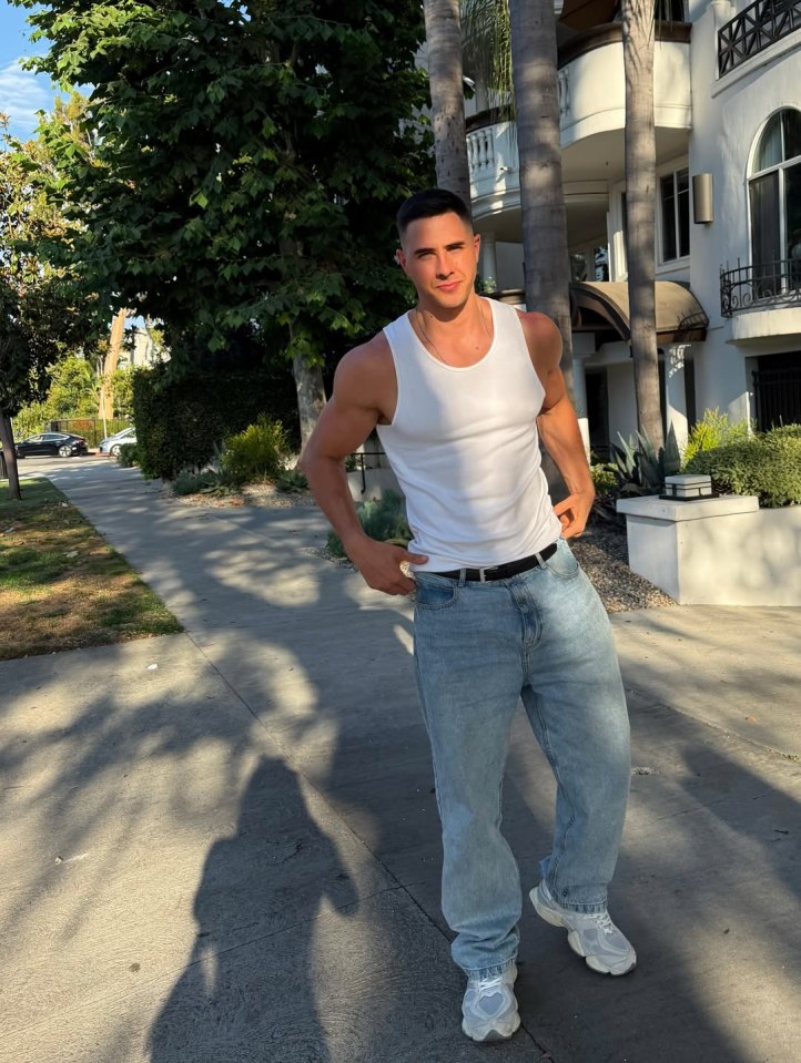 Man in white tank top and light wash jeans.