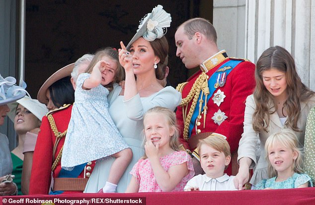 Kate is seen with Charlotte on her hip as the three-year-old princess rubs her eyes