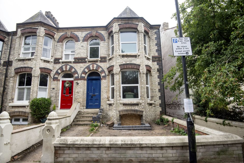A house under construction with a red and blue door.