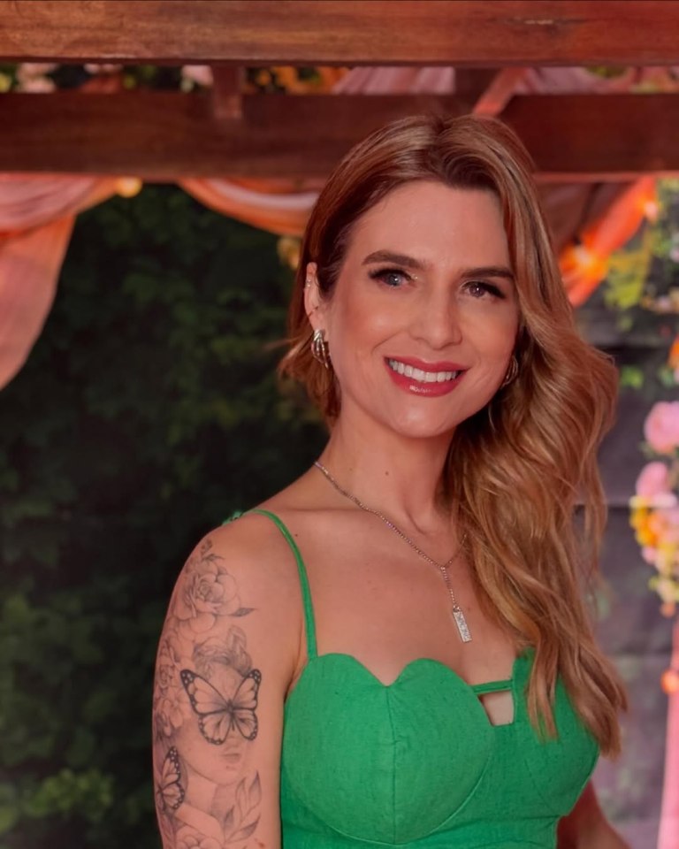 Woman with a butterfly tattoo smiling.