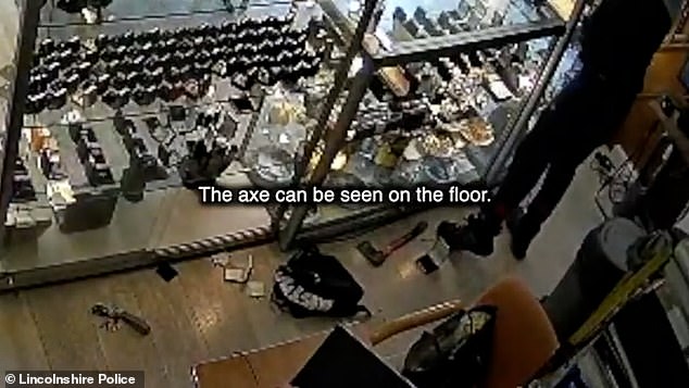Over the course of a nine minute thieving spree, the two men were captured on camera grabbing watches, rings and necklaces from the display cabinets. The pair, who stuffed the jewels into both black bags and their pockets, laid the axe out on the floor (pictured)