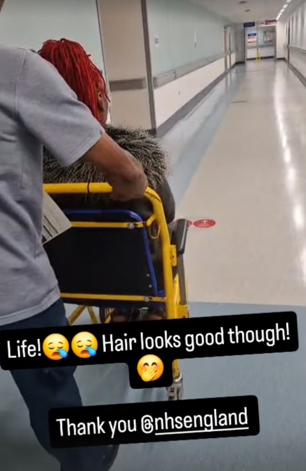 Woman in wheelchair being pushed down hospital corridor.