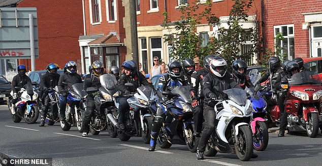 The pack of leather clad bikers escorted the car through the streets of the town, roaring their engines and sounding their horns