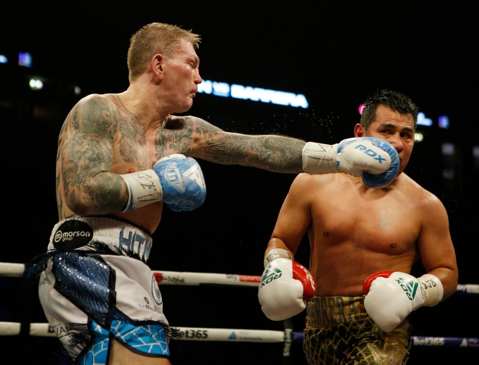 Ricky Hatton punches Marco Antonio Barrera during a boxing match.
