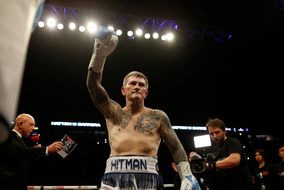 Ricky Hatton raises his arm in victory after a boxing match.