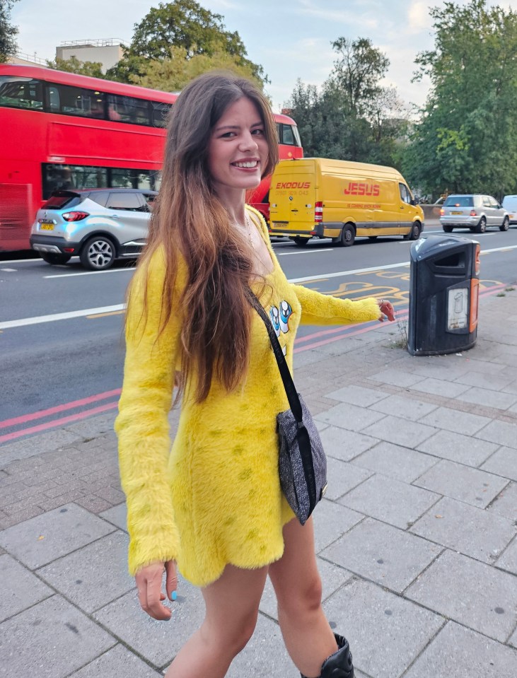 Woman in yellow dress walking down a city street.