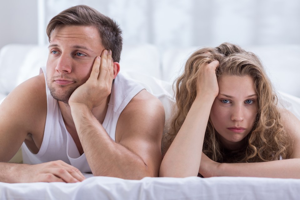 a man and a woman laying on a bed with their heads on their hands