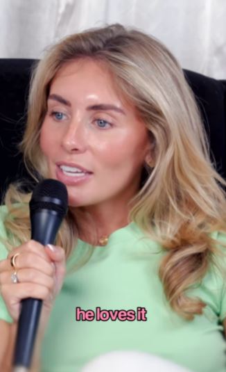 Woman speaking into a microphone; text overlay reads "he loves it."