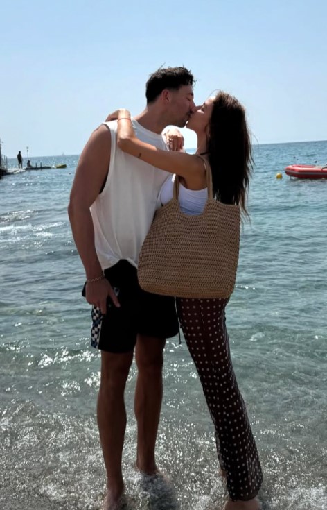 Couple kissing on a beach.