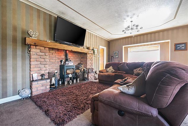 The TV in the living room is placed above the fireplace and just below the ceiling